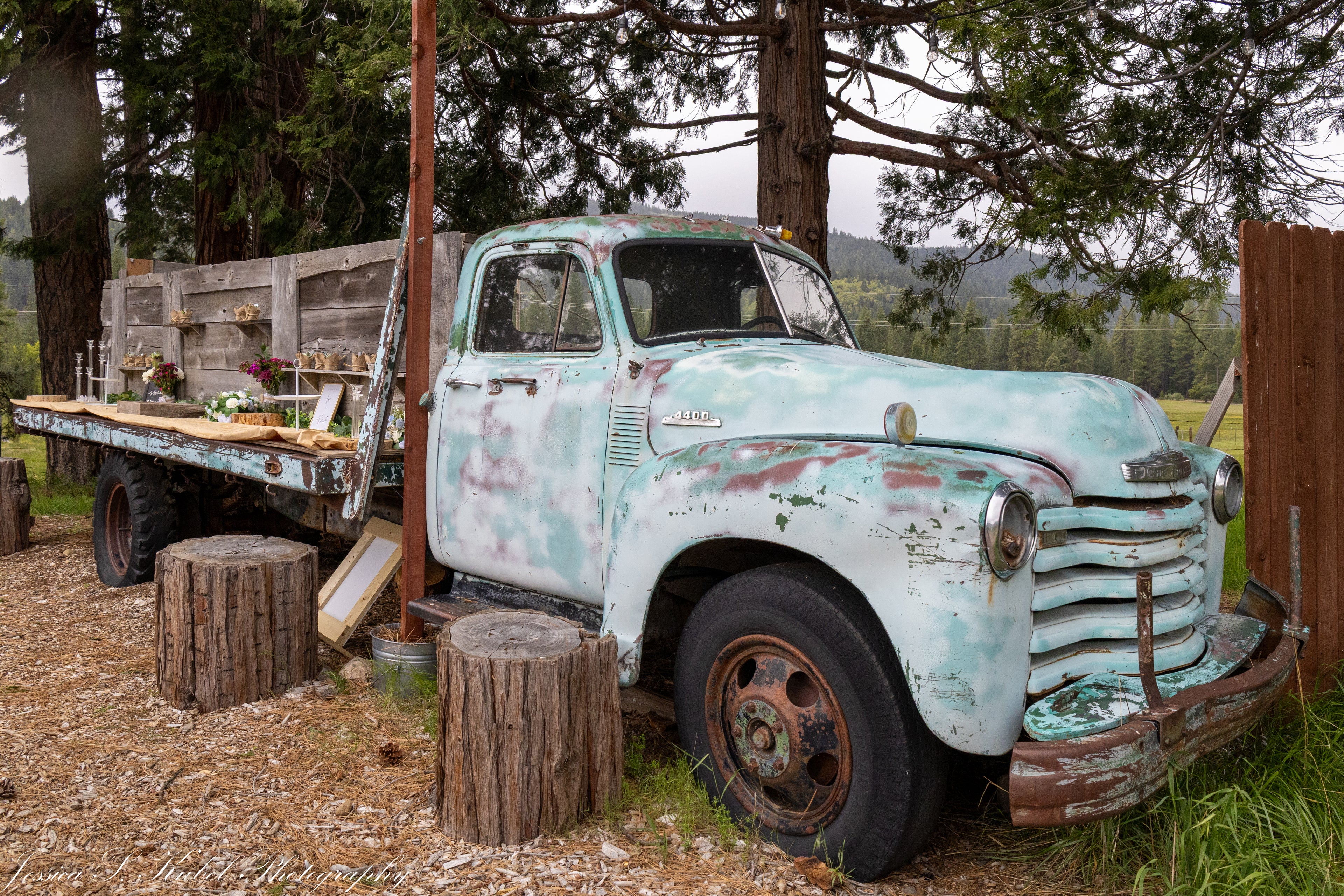 Old rusted truck with a wooden platform in a rustic outdoor setting