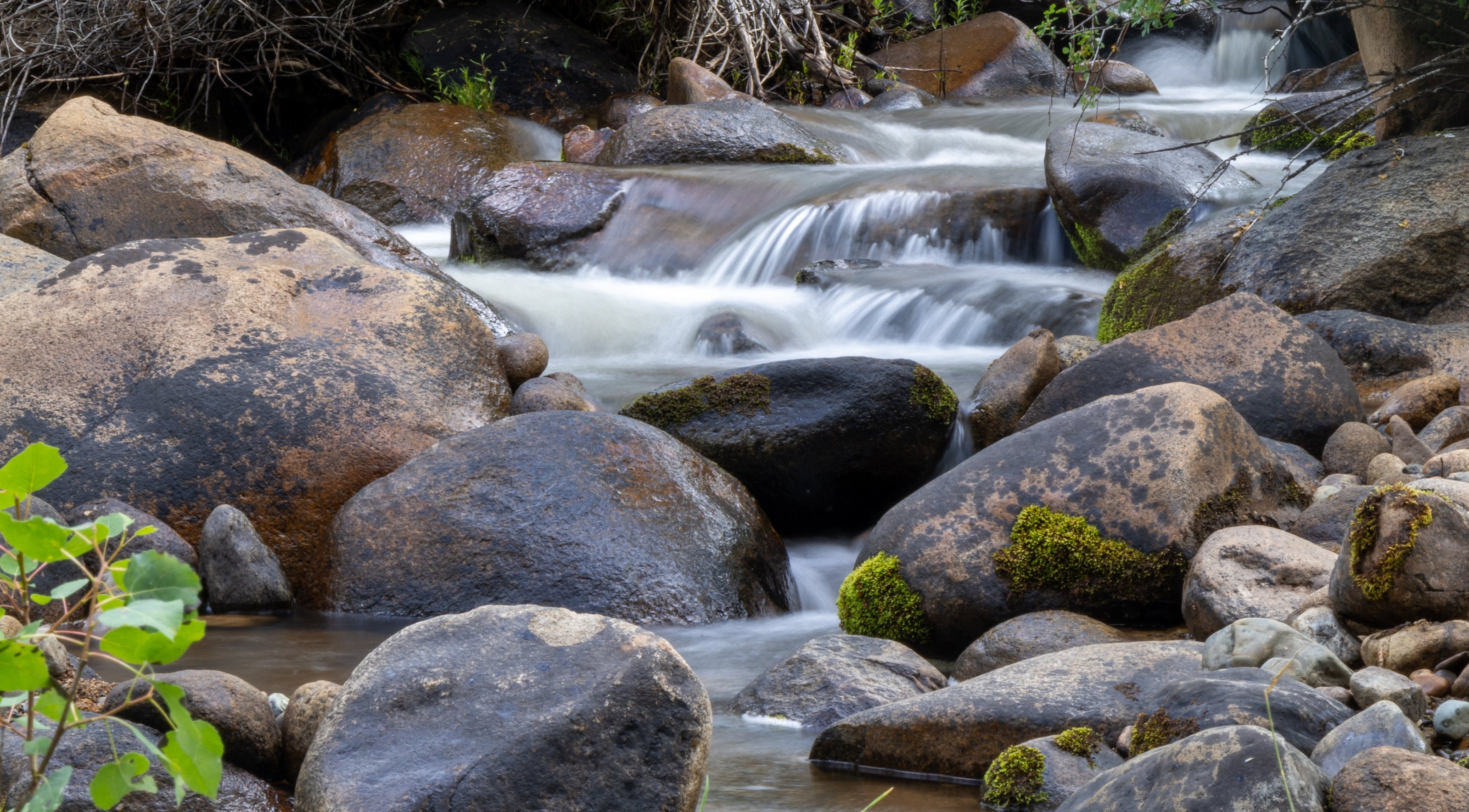 Stream flowing over rocks with waterfalls in a natural setting